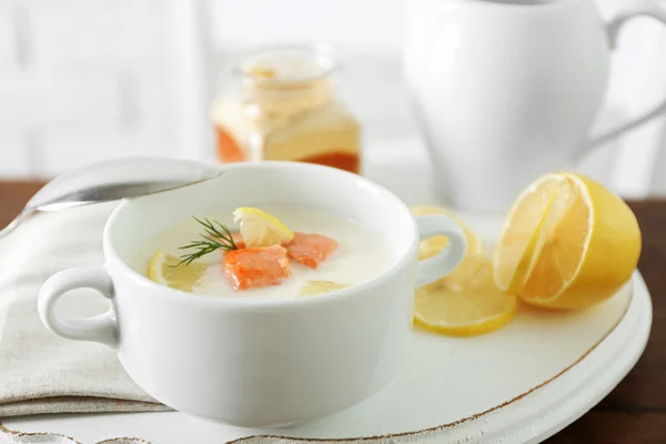 Delicious salmon cream soup with sliced lemon on white tray, close up — Stock Photo, Image