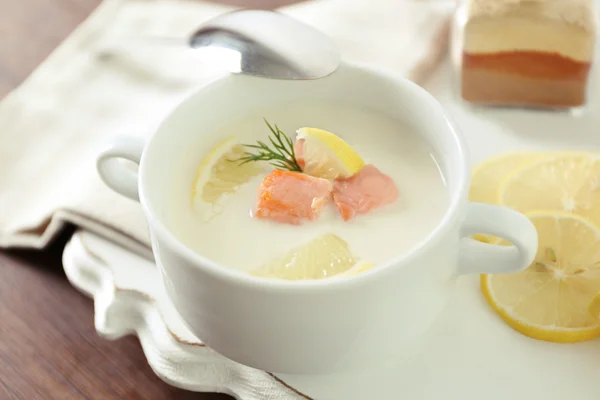 Delicious salmon cream soup with sliced lemon on white tray, close up — Stock Photo, Image