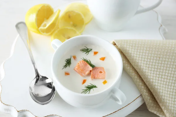 Deliciosa sopa de crema de salmón sobre blanco decorado con limón y servilleta de algodón en el restaurante — Foto de Stock