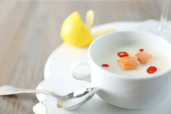 Sabrosa sopa de crema de salmón, vino y limón en la mesa de madera, de cerca — Foto de Stock