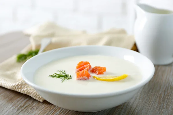 Heerlijke crème soep met vis en gesneden citroen op houten tafel — Stockfoto