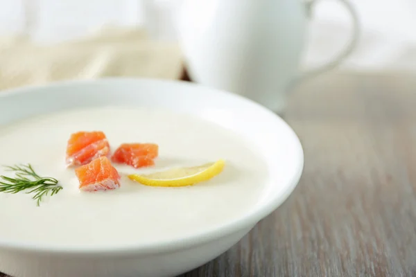Heerlijke crème soep met vis en gesneden citroen op houten tafel — Stockfoto