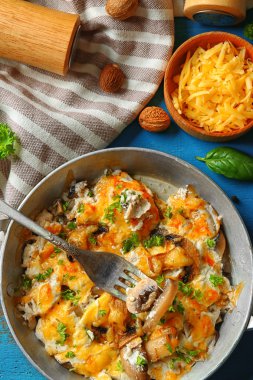 Kavrulmuş mantar, tavuk ve peynir graten renk ahşap arka plan üzerinde tavada