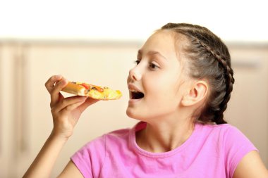 Küçük kız evde pizza yemek