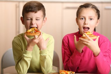 Children eating pizza at home clipart