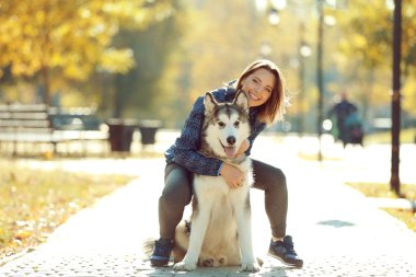 Mutlu genç kadın ile onun köpek parkta yürüyüş