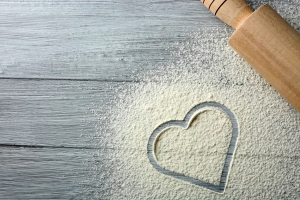 Heart of flour and rolling pin on color wooden background — Stock Photo, Image