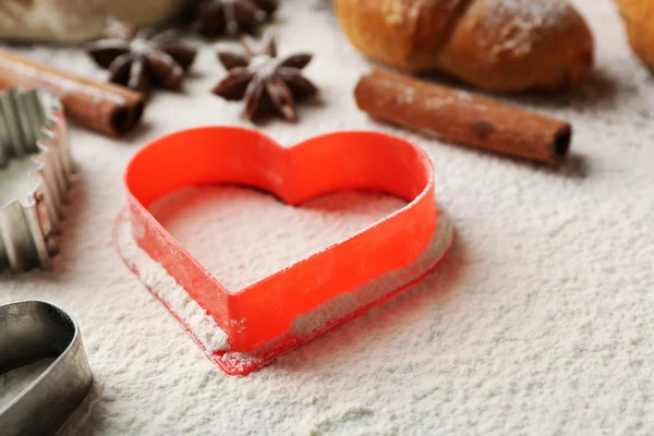 Heart of flour, croissant and spices on gray background — Stock Photo, Image