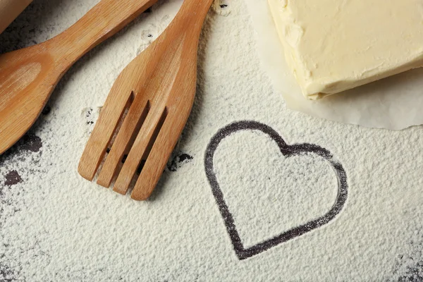 Cuore di farina e utensili da cucina su sfondo di legno — Foto Stock