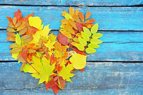 Coeur de feuilles d'automne colorées sur fond en bois — Photo