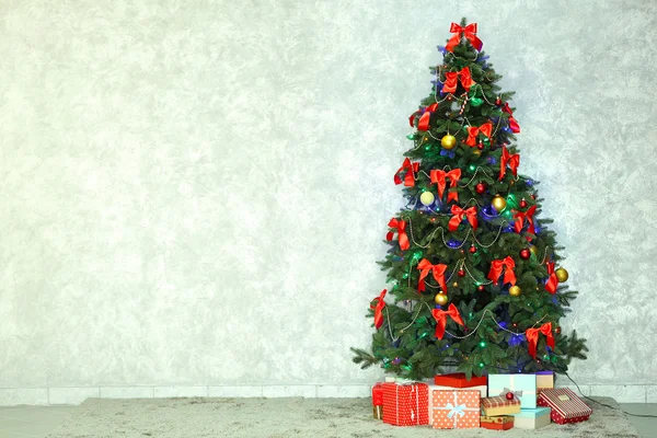 Árbol de Navidad decorado sobre fondo de pared claro —  Fotos de Stock
