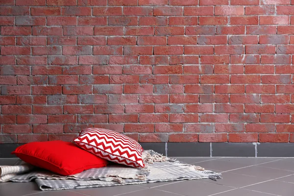 Многоцветные подушки на фоне кирпичной стены — стоковое фото