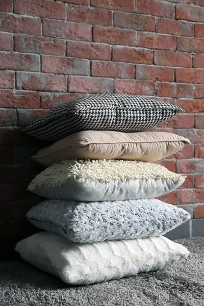 レンガ壁の背景にカラフルな枕 — ストック写真