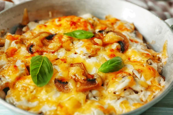 Cogumelos assados, frango e queijo gratinado em panela, sobre fundo de madeira — Fotografia de Stock