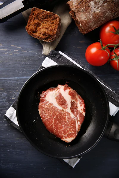 Bife de carne marmorizada na panela e especiarias na cor de fundo de madeira — Fotografia de Stock