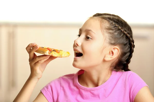 집에서 피자를 먹는 어린 소녀 — 스톡 사진
