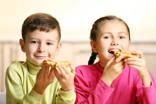 Crianças comendo pizza em casa — Fotografia de Stock