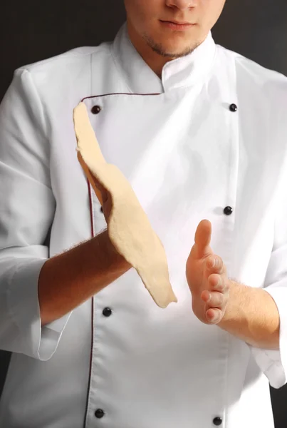 Hands preparing dough basis for pizza on the wooden table, close-up — Stock Photo, Image