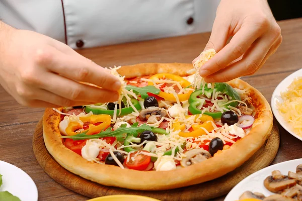 Koken maken heerlijke pizza in het restaurant, close-up — Stockfoto