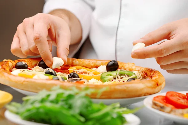 Köchin zubereitet köstliche Pizza im Restaurant, Nahaufnahme — Stockfoto