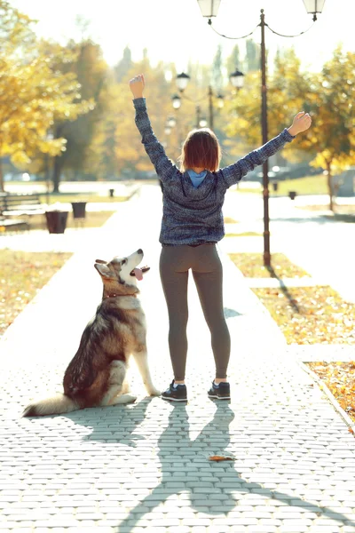 Feliz joven mujer caminando con su perro en el parque —  Fotos de Stock