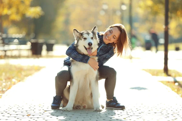 Kvinna promenader med hund i parken — Stockfoto