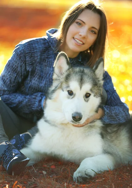 Šťastná mladá žena seděla se svým psem na trávě v parku — Stock fotografie