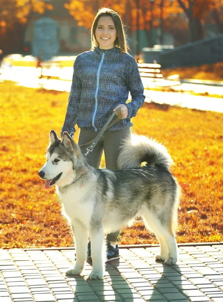 Szczęśliwa młoda kobieta spaceru z psem w parku — Zdjęcie stockowe