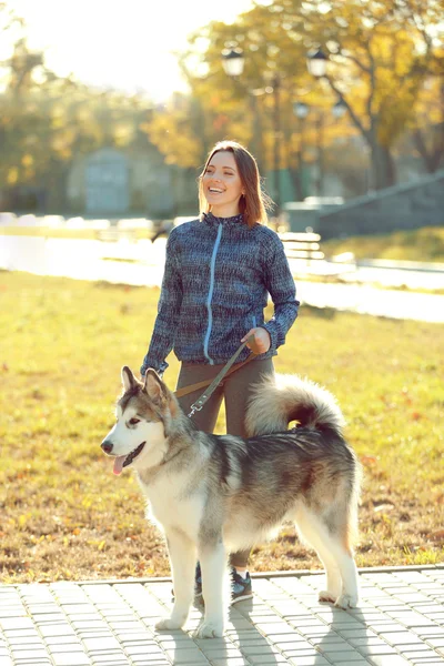 Feliz joven mujer caminando con su perro en el parque —  Fotos de Stock