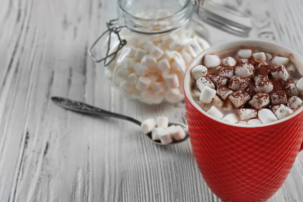 Una taza de sabroso cacao y malvavisco sobre fondo de madera blanca — Foto de Stock