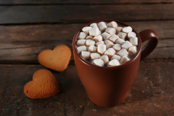 Uma xícara de cacau saboroso e marshmallow na mesa de madeira — Fotografia de Stock