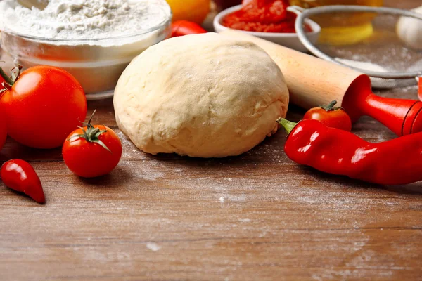Dough balls and ingredients for pizza, on the table — Stock Photo, Image