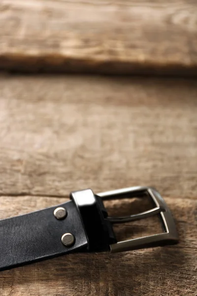 Cinturón de cuero con hebilla sobre fondo de madera —  Fotos de Stock