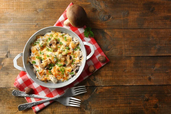 Roasted mushrooms, chicken and cheese gratin in pan, on wooden background — Stock Image Roasted mushrooms, chicken and cheese gratin in pan, on wooden background Royalty Free Stock Photos