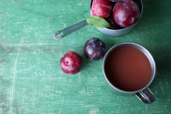 Delizioso succo di prugna con frutta sul tavolo di legno da vicino — Foto Stock