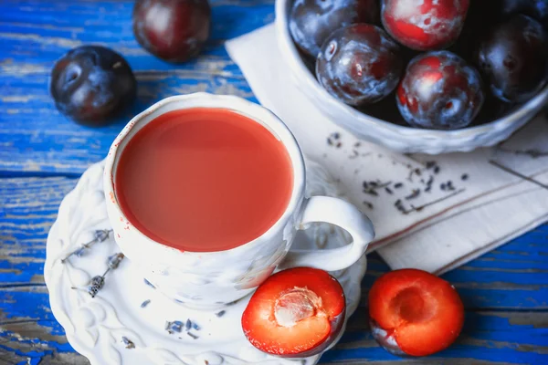 Delizioso succo di prugna con frutta sul tavolo di legno da vicino — Foto Stock