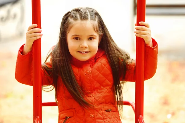 Little girl on swing in city park — Stock Photo, Image