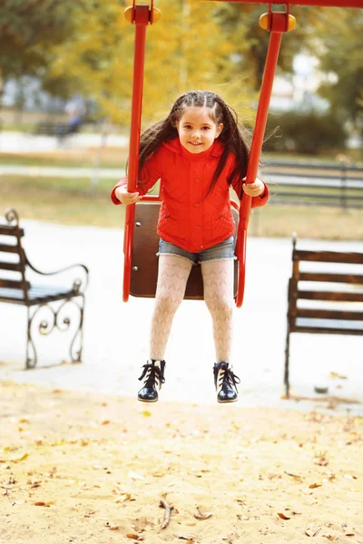 Meisje op schommel in stadspark — Stockfoto