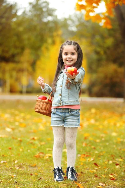 사과, 야외의 바구니를 들고 아름 다운 어린 소녀 — 스톡 사진