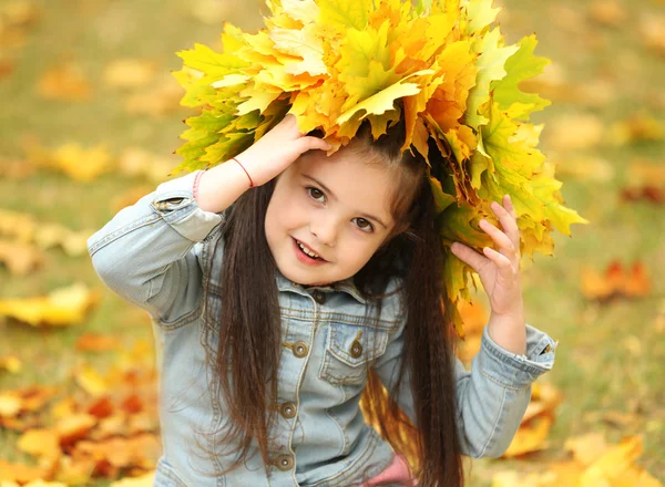 Gelukkig jong meisje gele herfst krans in park — Stockfoto
