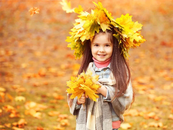 Menina feliz no outono amarelo grinalda no parque — Fotografia de Stock