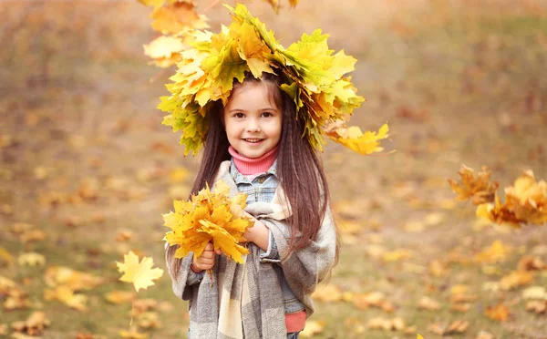 Glückliches junges Mädchen in gelbem Herbstkranz im Park — Stockfoto