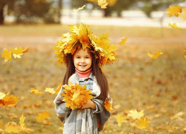 Feliz joven en la corona de otoño amarillo en el parque — Foto de Stock