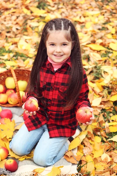 Hermosa niña sosteniendo cesta de manzanas, al aire libre —  Fotos de Stock