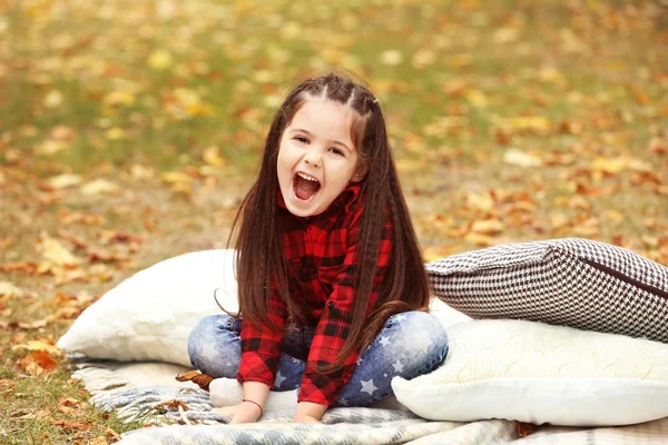 Ekose sonbahar parkta oturan mutlu genç kız — Stok fotoğraf