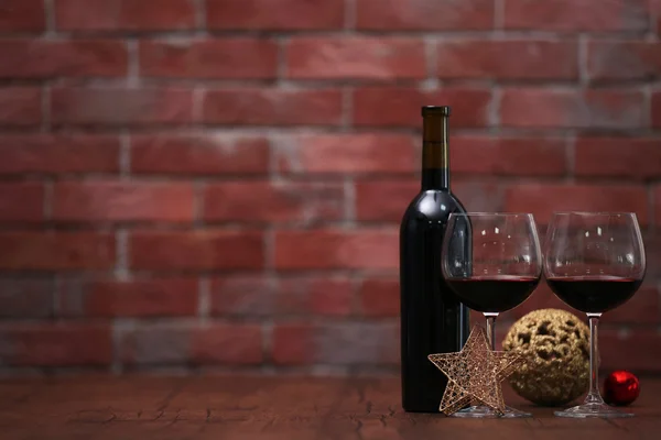 Rött vin och Christmas Ornament på träbord på vägg brick bakgrund — Stockfoto