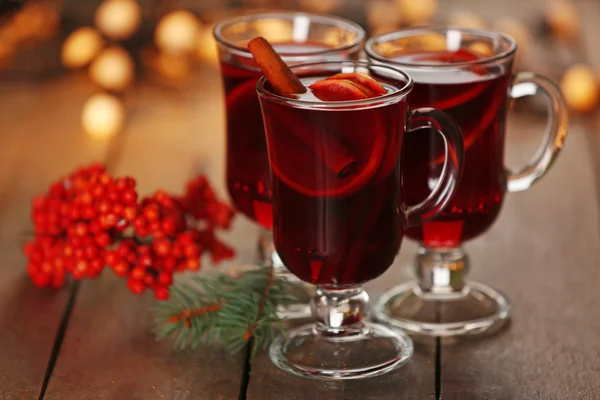 Glödgat vin med kryddor och julgran på trä bakgrund — Stockfoto
