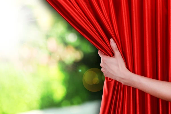 Mão abre cortina vermelha — Fotografia de Stock