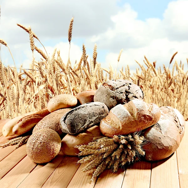 Färskt bröd på wheatfield bakgrund — Stockfoto