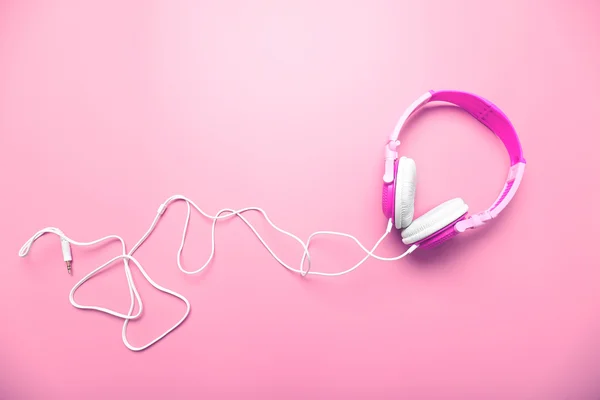 Auriculares sobre fondo rosa — Foto de Stock